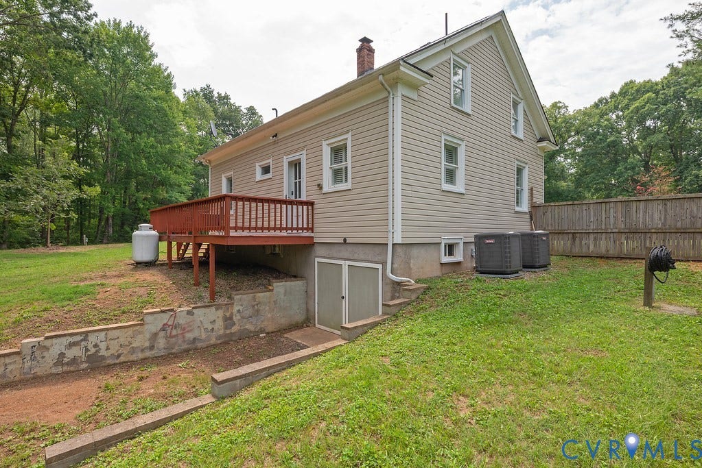 4808 River Road W Road, Goochland, VA 23063 Rear exterior featuring horizontal siding, a red-stained wood deck with railings, and a walk-out basement entrance