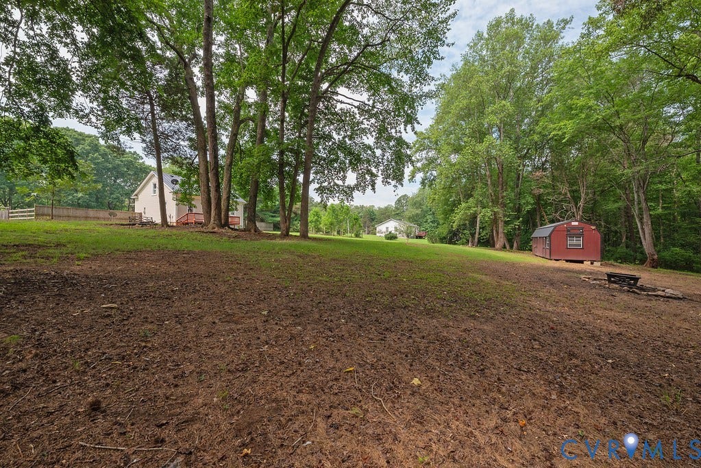 4808 River Road W Road, Goochland, VA 23063 Expansive outdoor space featuring a red storage shed, a defined fire pit area, and mature trees.