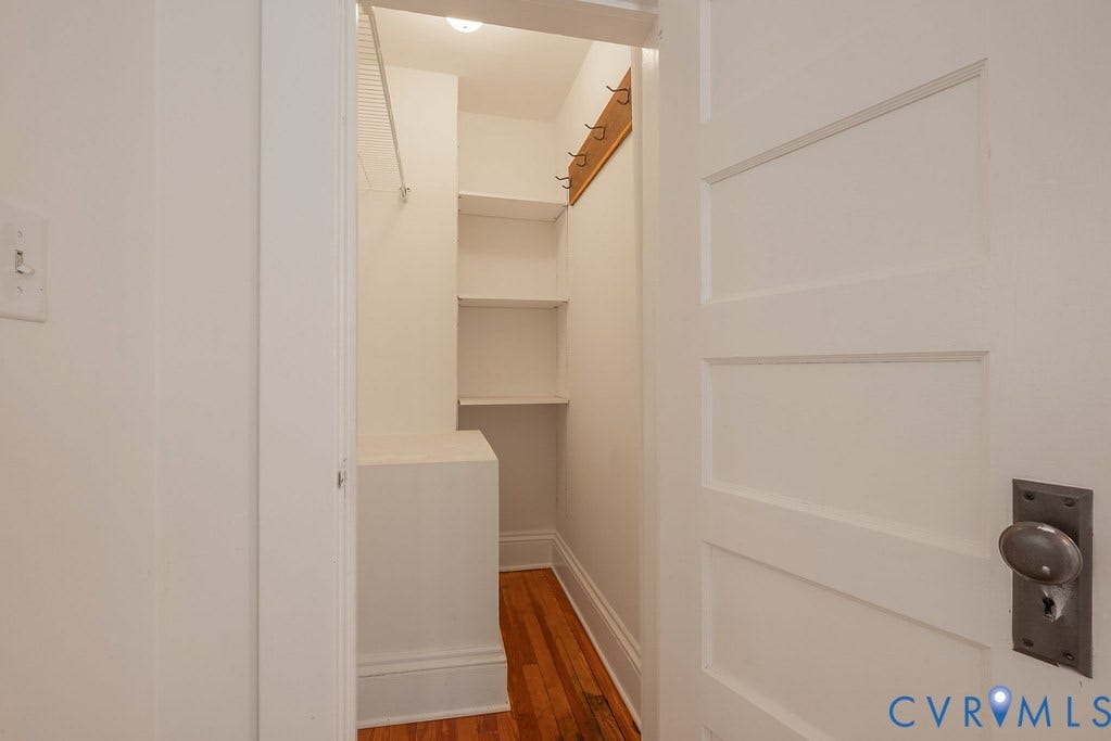 4808 River Road W Road, Goochland, VA 23063 Walk-in closet featuring wood-finish flooring, built-in shelving, and a wall-mounted coat rack