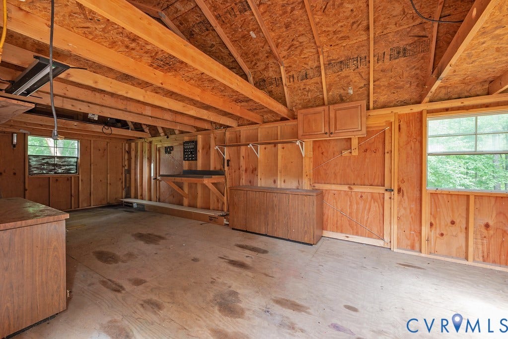 4808 River Road W Road, Goochland, VA 23063 Spacious utility building featuring exposed wood framing, two windows, built-in shelving, and built-in cabinetry