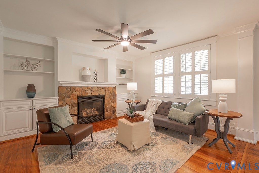 4808 River Road W Road, Goochland, VA 23063 Living area featuring a stone-clad fireplace with mantel, built-in shelving and cabinetry, shuttered windows, and wood-finish flooring