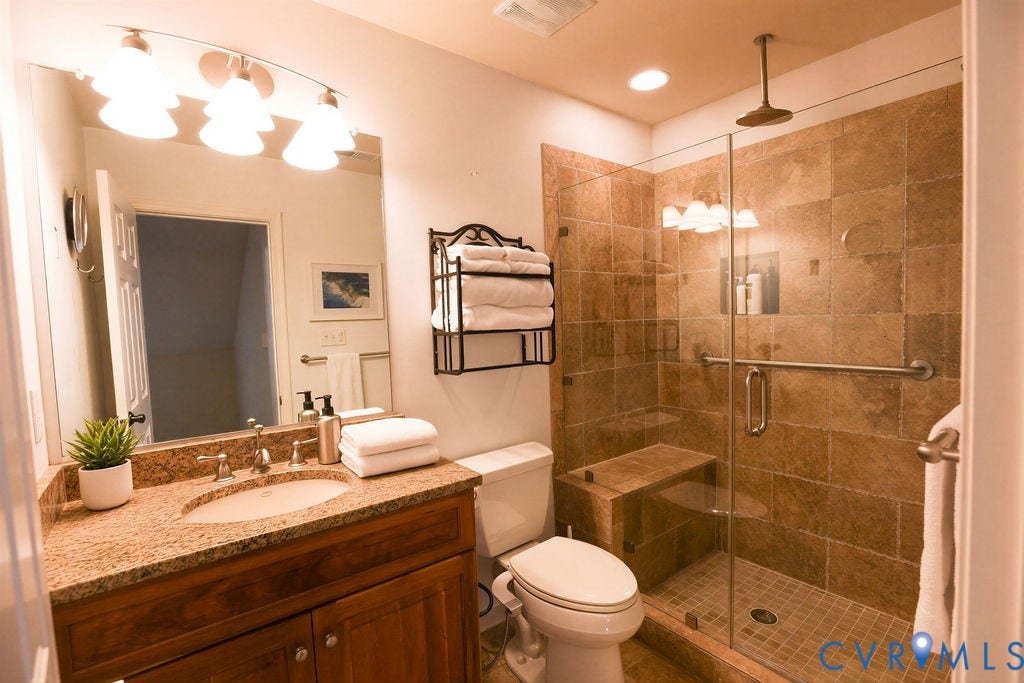 14007 Shawhan Court, Charter Colony, Midlothian, VA 23114 Glass-enclosed shower with a built-in bench, rainfall showerhead, and tiled walls