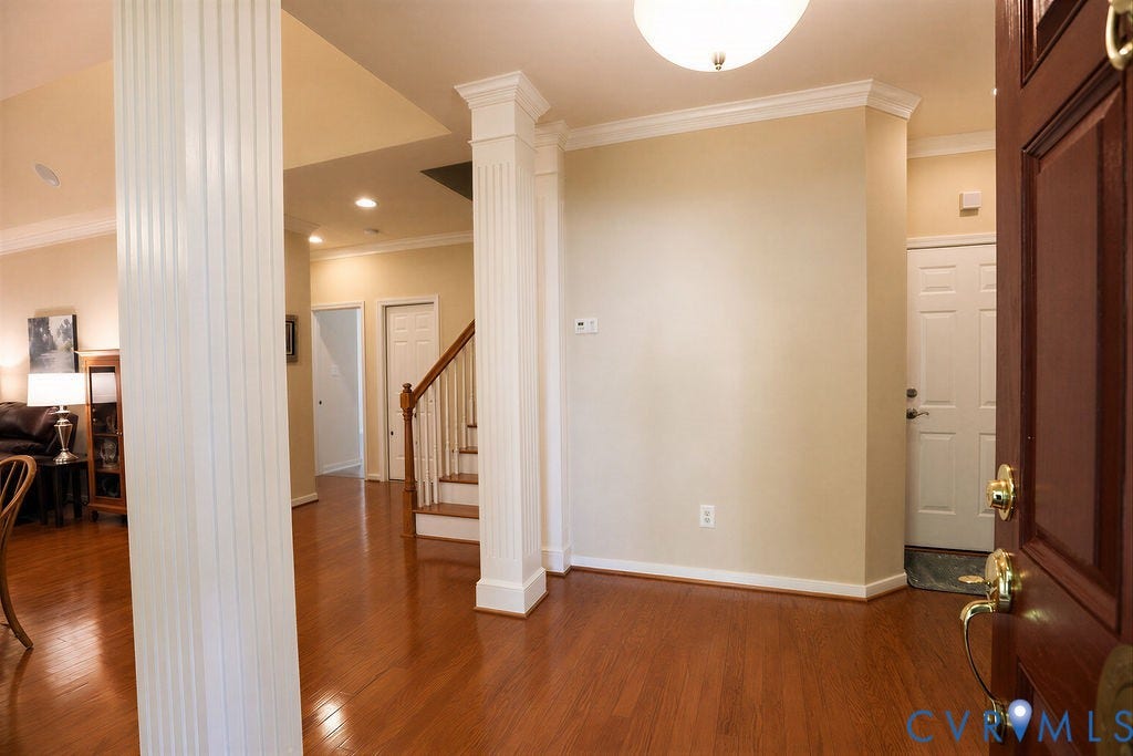 14007 Shawhan Court, Charter Colony, Midlothian, VA 23114 Rich wood-finish flooring extends throughout the space, complemented by recessed lighting and decorative fluted columns