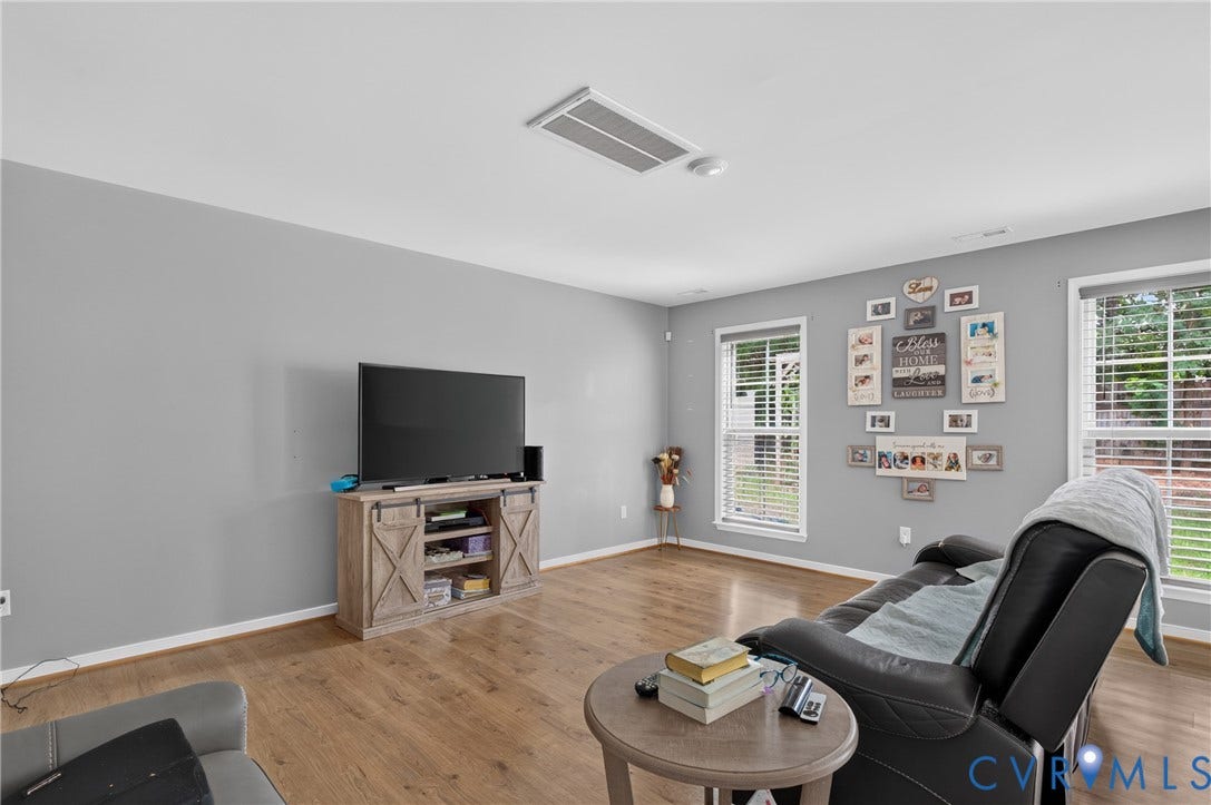 311 Cardinal Road, Countryside, Louisa, VA 23093 Spacious room featuring wood-finish flooring, light gray wall paint, and multiple windows with horizontal blinds