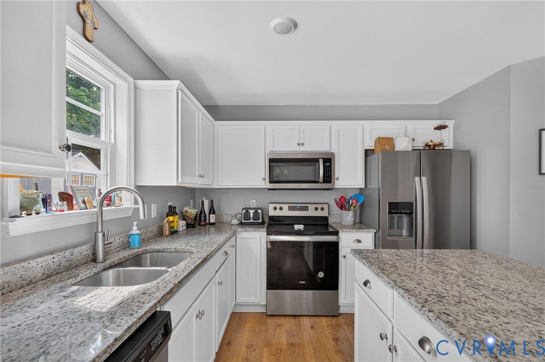 311 Cardinal Road, Countryside, Louisa, VA 23093 Bright kitchen featuring white cabinetry, granite-finish countertops, stainless steel appliances, a double basin sink, and wood-finish flooring