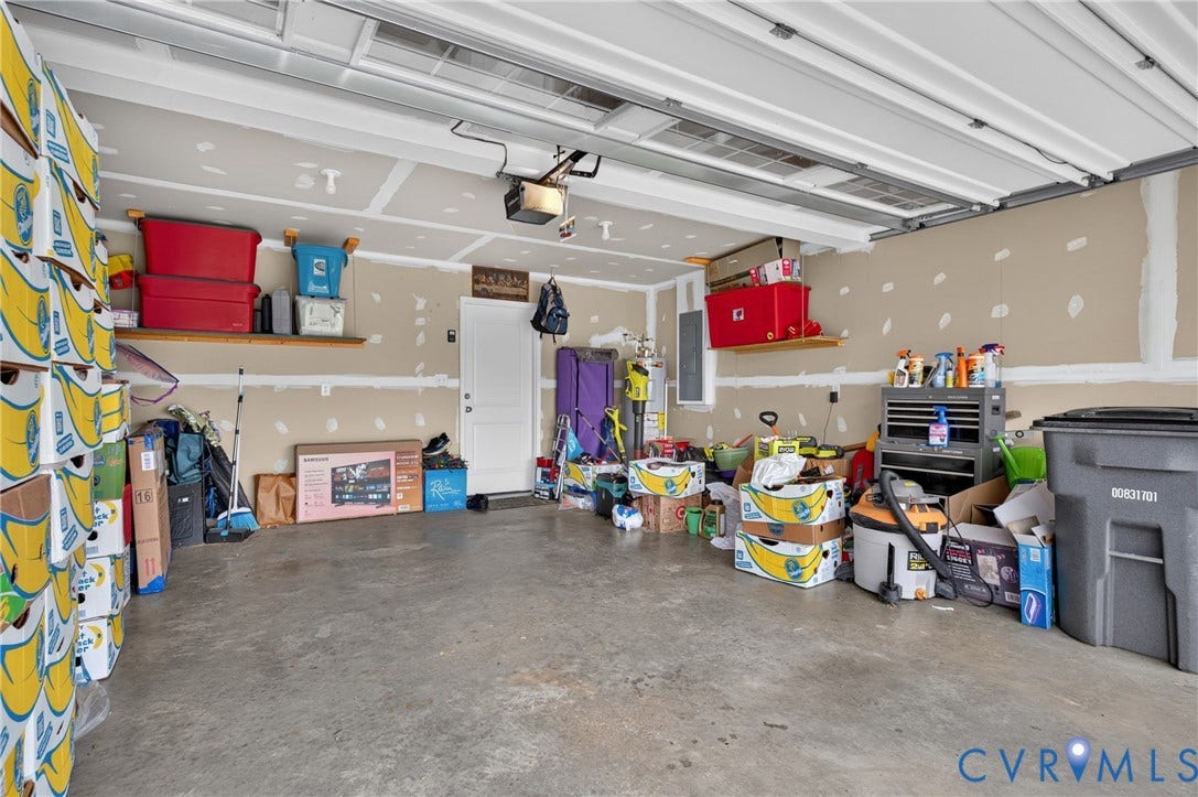 311 Cardinal Road, Countryside, Louisa, VA 23093 Spacious garage featuring a concrete floor, overhead garage door with automatic opener, and a side access door