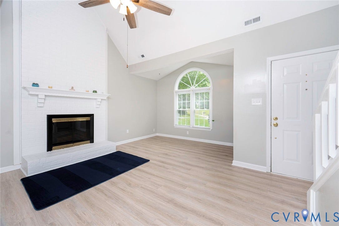 14001 Branched Antler Drive, Antler Ridge, Midlothian, VA 23112 Vaulted ceiling with a ceiling fan, white brick fireplace with mantel, wood-finish flooring, and an arched window