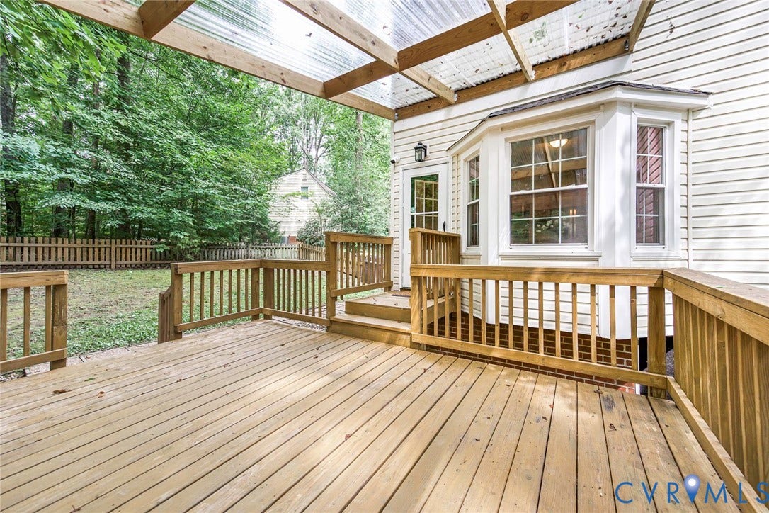 14001 Branched Antler Drive, Antler Ridge, Midlothian, VA 23112 Expansive wood deck with a translucent panel roof, offering direct access to the interior through a glass-paneled door