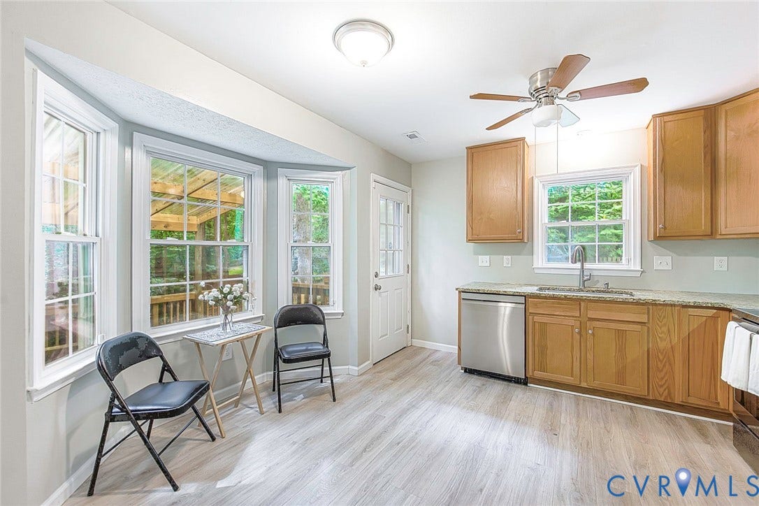 14001 Branched Antler Drive, Antler Ridge, Midlothian, VA 23112 Bay window with multiple panes, wood-finish flooring, wood cabinetry, stainless steel dishwasher, and a ceiling fan with integrated lighting