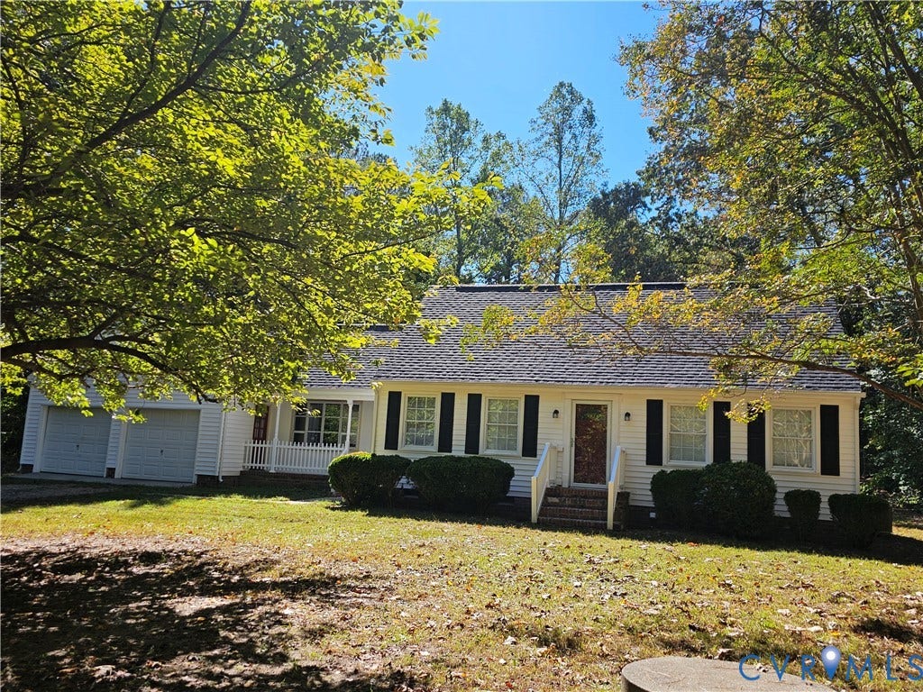 12870 King William Road, King William, VA 23086 Single-story exterior featuring white horizontal siding, dark window shutters, a front porch with railing, and an attached two-car garage