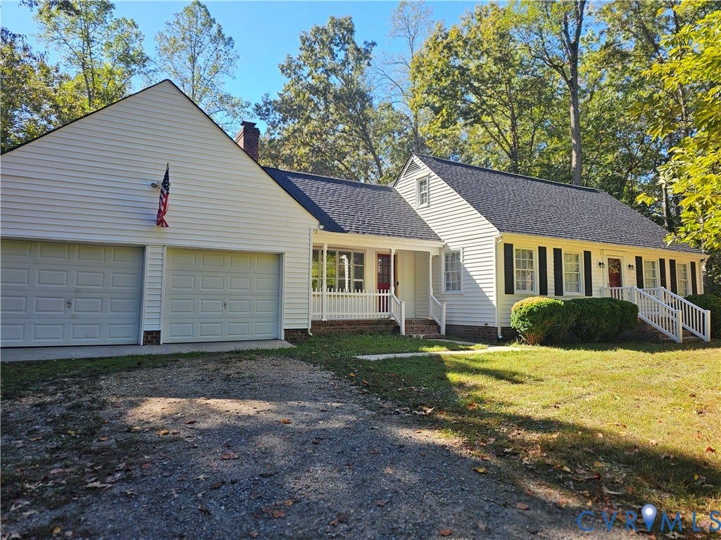 12870 King William Road, King William, VA 23086 Exterior featuring white horizontal siding, a two-car garage, multi-gabled roofline, covered front porches with balustrades, and multi-pane windows with shutters