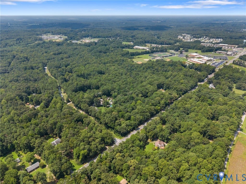 12870 King William Road, King William, VA 23086 Expansive wooded property featuring a residential structure, surrounding roadways, and distant commercial structures