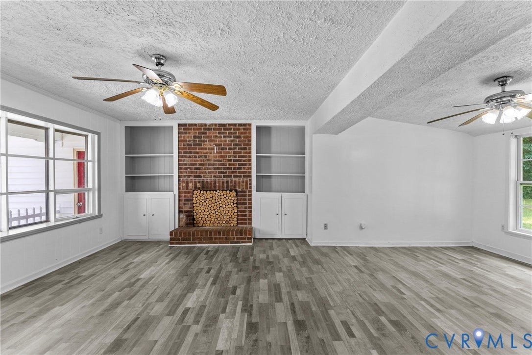 12870 King William Road, King William, VA 23086 Wood-finish flooring, brick fireplace with hearth, built-in shelving, built-in cabinetry, and ceiling fans