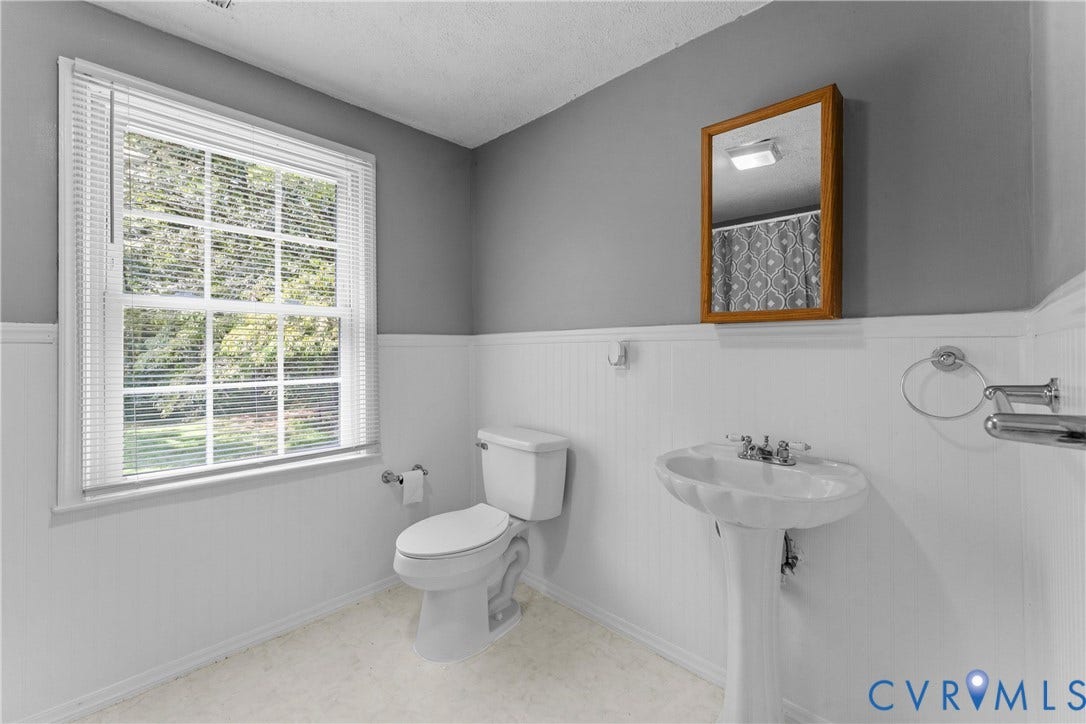 12870 King William Road, King William, VA 23086 White pedestal sink with chrome faucet, toilet, and a window with horizontal blinds