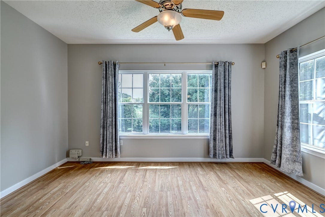 4602 Twin Hickory Lake Drive, Twin Hickory, Glen Allen, VA 23059 Bright and spacious room featuring gleaming wood-finish flooring, abundant natural light from multi-pane windows with custom drapery, and a ceiling fan with integrated lighting