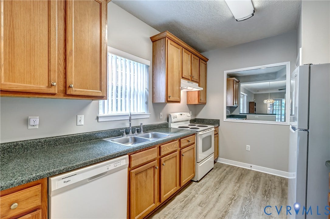 4602 Twin Hickory Lake Drive, Twin Hickory, Glen Allen, VA 23059 Galley-style kitchen featuring warm wood cabinetry, speckled green countertops, and stainless steel appliances including a dishwasher and electric range