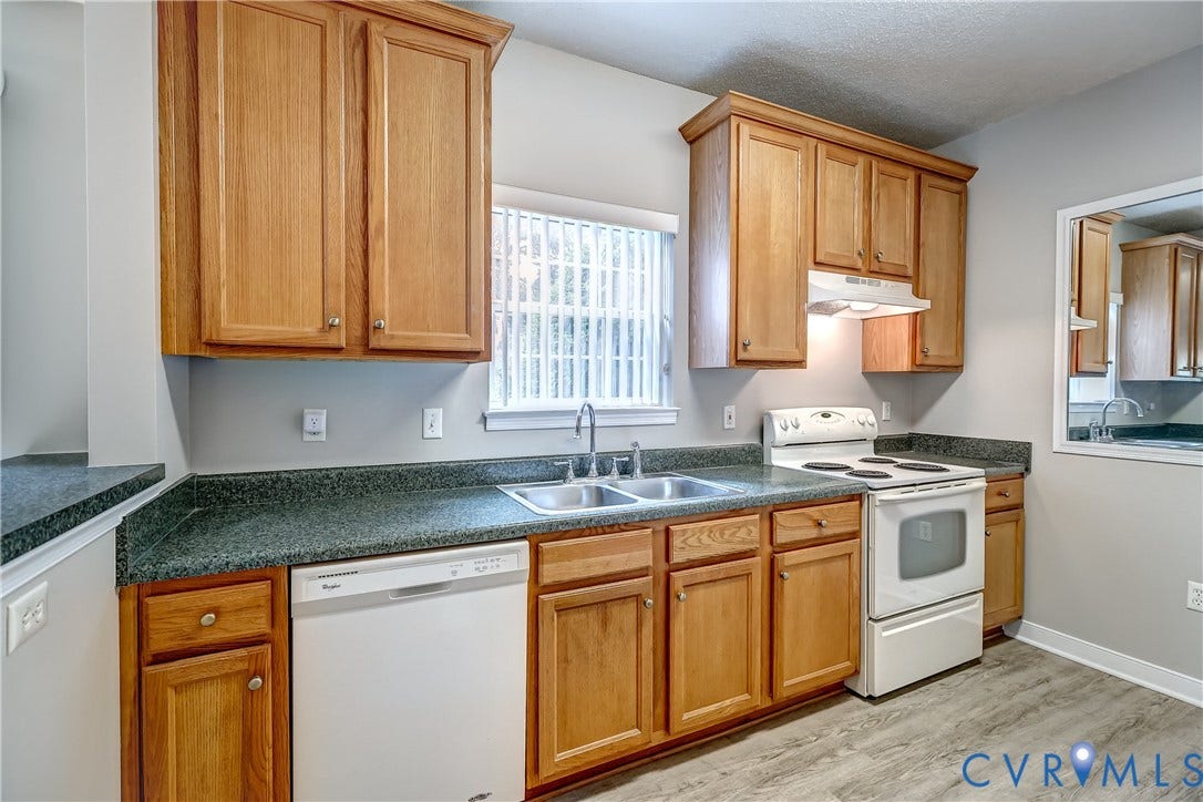 4602 Twin Hickory Lake Drive, Twin Hickory, Glen Allen, VA 23059 Warm wood cabinetry and speckled green countertops define this galley-style kitchen, featuring stainless steel appliances, a dual-basin sink with chrome fixtures, and ample storage throughout