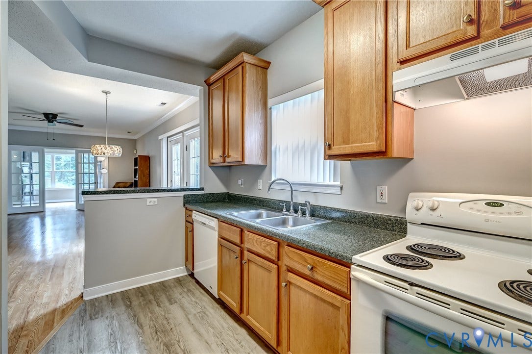 4602 Twin Hickory Lake Drive, Twin Hickory, Glen Allen, VA 23059 Kitchen featuring wood-finish cabinetry, dark speckled countertops, and a double basin sink with a window overhead