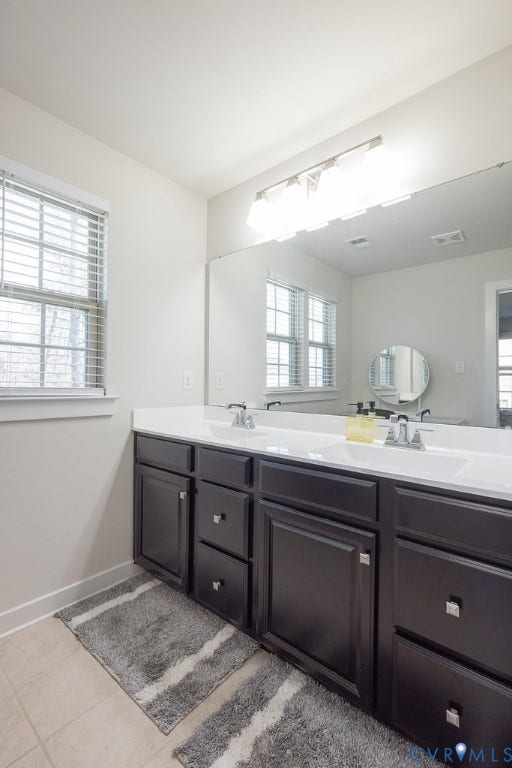 10419 Centralia Station Road, Chester, VA 23831 Bathroom vanity featuring dual sinks, dark cabinetry with chrome hardware, a white countertop, and a large wall-mounted mirror