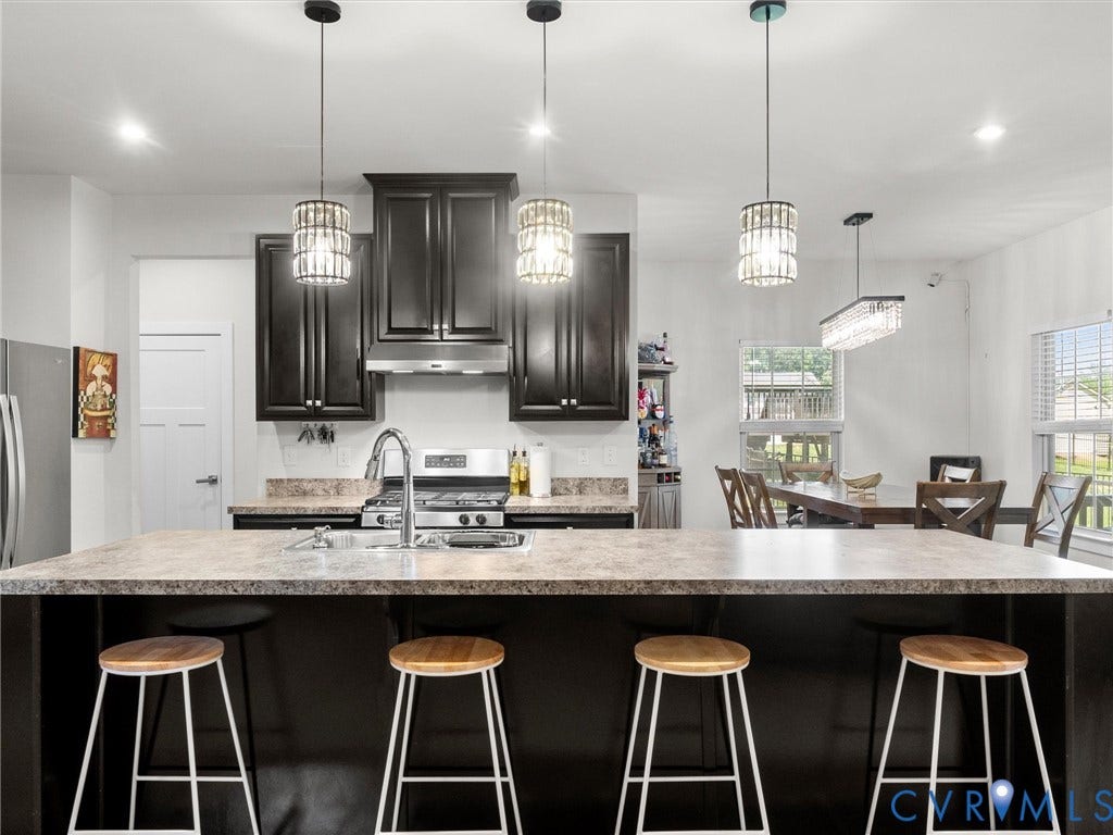 10419 Centralia Station Road, Chester, VA 23831 Kitchen featuring a large island with seating, dark wood cabinetry, stainless steel appliances, a gas range with a hood, and decorative pendant lighting