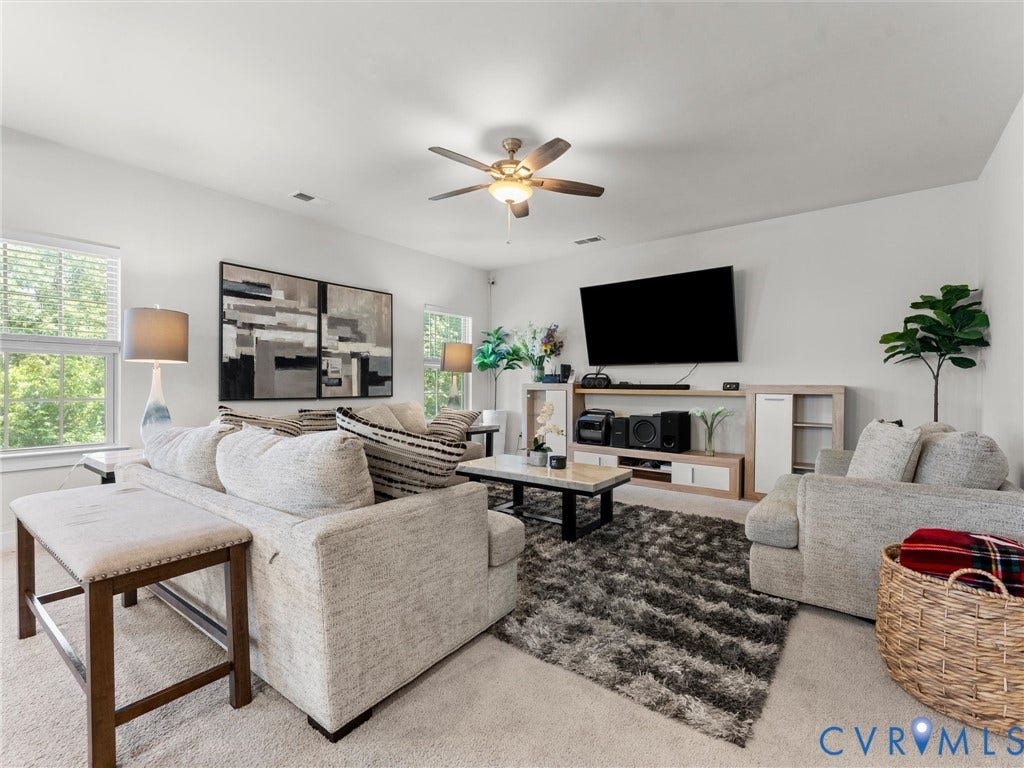 10419 Centralia Station Road, Chester, VA 23831 Carpeted living area featuring multiple windows, a ceiling fan with integrated lighting, and white wall finishes