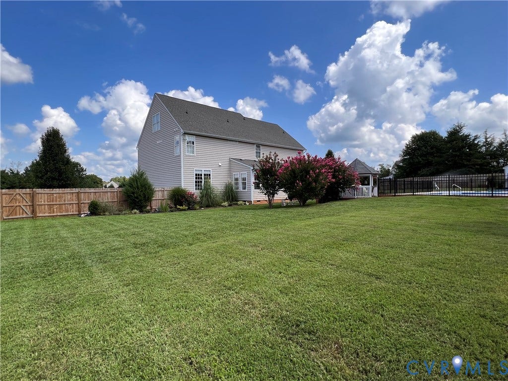 3267 Bayberry Lane, Goochland, VA 23063 Spacious backyard featuring a large green lawn, wood privacy fencing, and mature landscaping