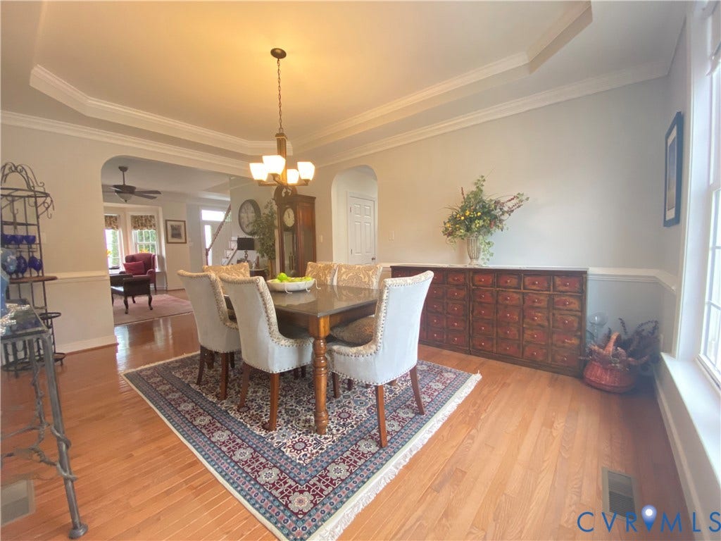 3267 Bayberry Lane, Goochland, VA 23063 Dining area featuring hardwood flooring, tray ceiling with crown molding, wainscoting, and an arched entryway