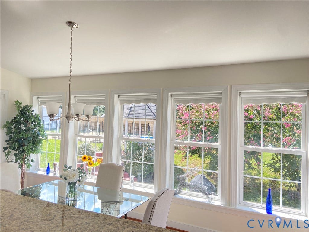 3267 Bayberry Lane, Goochland, VA 23063 Dining area featuring a contemporary chandelier, multiple large windows with white trim, and a clear glass-top dining table