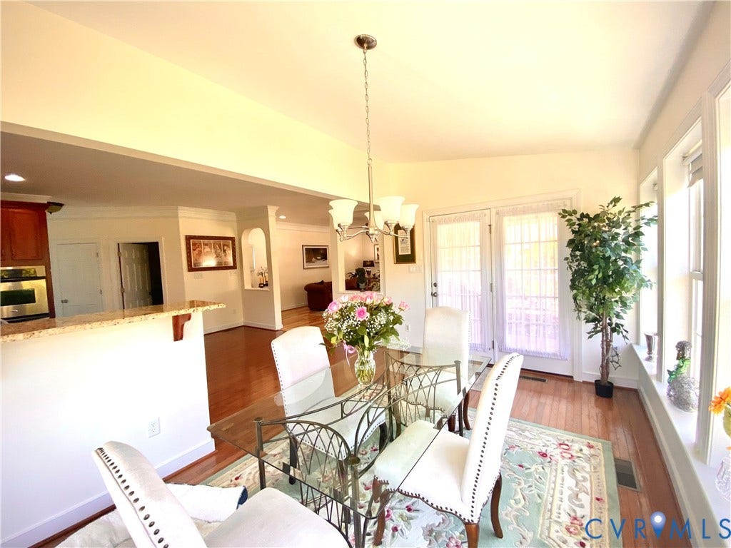 3267 Bayberry Lane, Goochland, VA 23063 Dining area featuring hardwood flooring, a multi-light chandelier, and abundant natural light from multiple windows and French doors