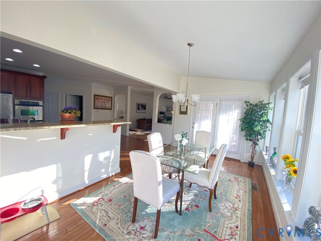 3267 Bayberry Lane, Goochland, VA 23063 Bright dining area featuring multiple windows, a glass-top table, and a chandelier