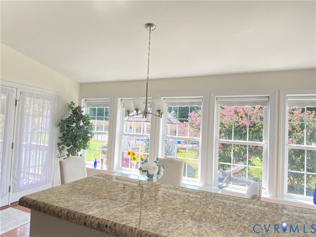 3267 Bayberry Lane, Goochland, VA 23063 Bright interior space featuring a large granite-look island, multiple windows with white trim, and a brushed nickel chandelier