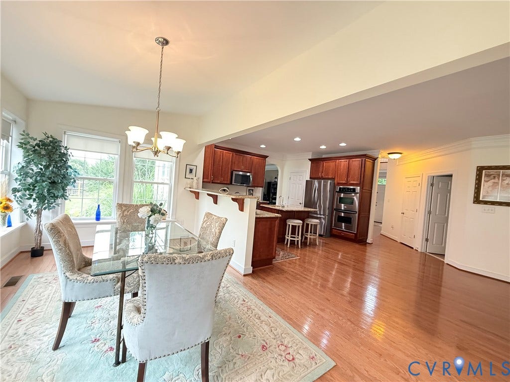 3267 Bayberry Lane, Goochland, VA 23063 Open-concept dining area featuring wood-finish flooring, a contemporary chandelier, and a breakfast bar