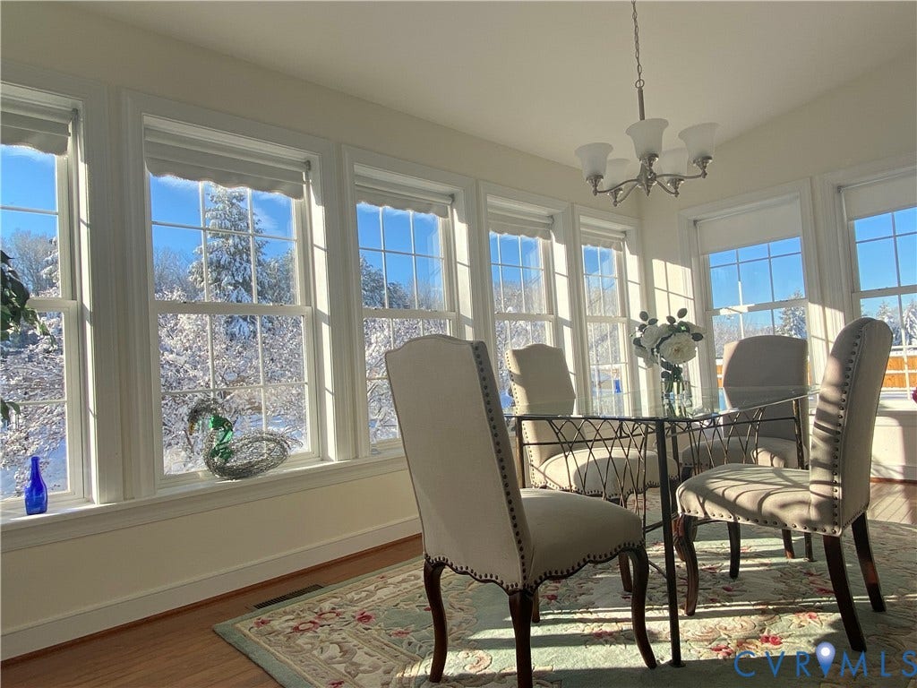 3267 Bayberry Lane, Goochland, VA 23063 Sun-drenched room featuring multiple windows, a ceiling-mounted chandelier, wood-finish flooring, and a decorative area rug
