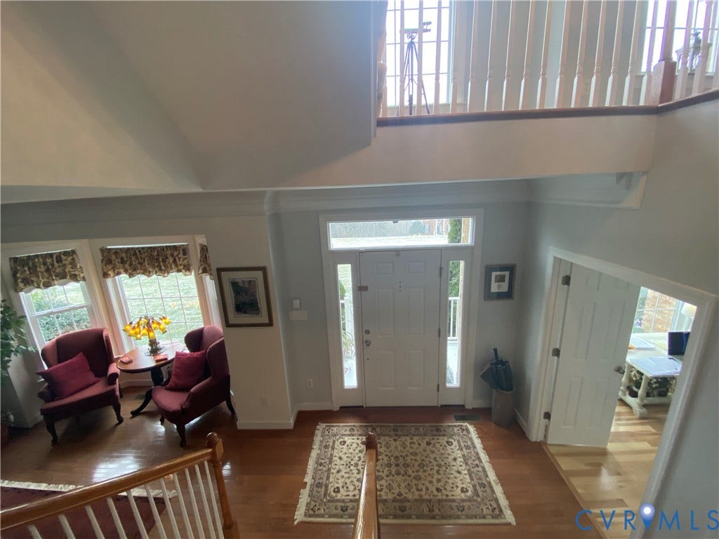 3267 Bayberry Lane, Goochland, VA 23063 Two-story foyer featuring wood-finish flooring, a prominent white entry door with sidelights, and a second-story landing with wood railings