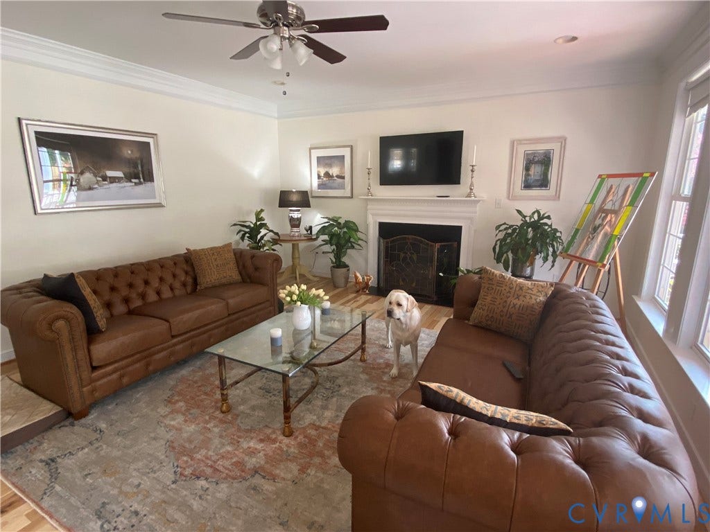 3267 Bayberry Lane, Goochland, VA 23063 Spacious living area featuring a central fireplace with an ornate screen, crown molding, wood-finish flooring, and multiple windows