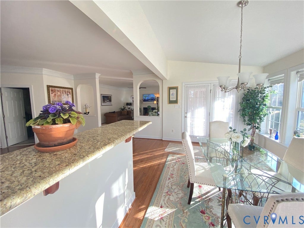 3267 Bayberry Lane, Goochland, VA 23063 Dining area featuring a glass-top table, multiple windows, and a chandelier with frosted shades