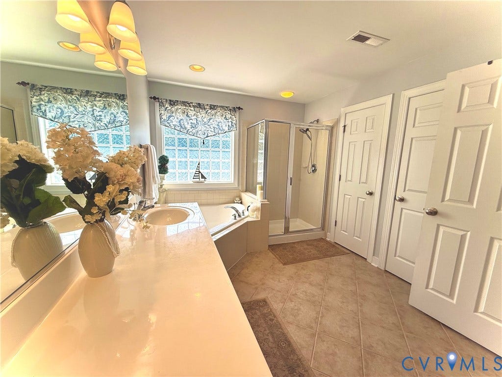 3267 Bayberry Lane, Goochland, VA 23063 Bathroom featuring a dual vanity with integrated sinks, a corner garden tub, a glass-enclosed shower, recessed lighting, and tile flooring