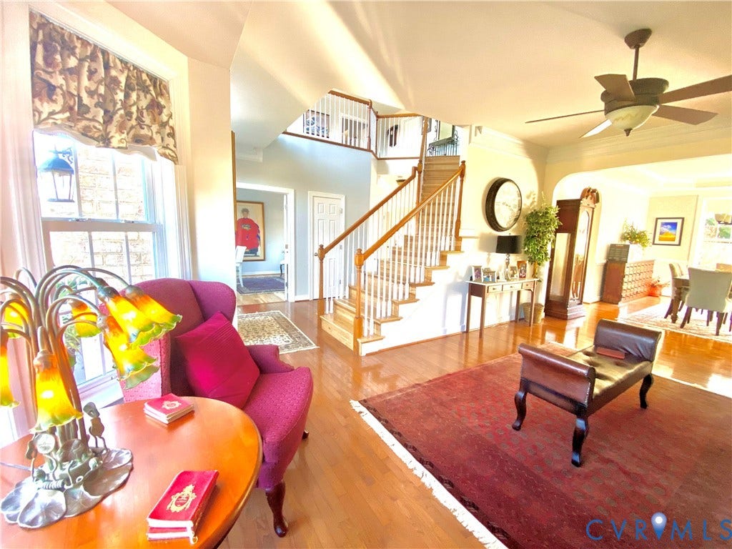 3267 Bayberry Lane, Goochland, VA 23063 Hardwood flooring extending throughout the main level, staircase with white spindles and wood handrail, and an arched entryway