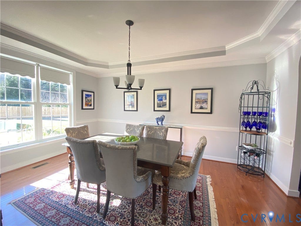 3267 Bayberry Lane, Goochland, VA 23063 Dining area featuring wood-finish flooring, a tray ceiling with crown molding, and a chandelier