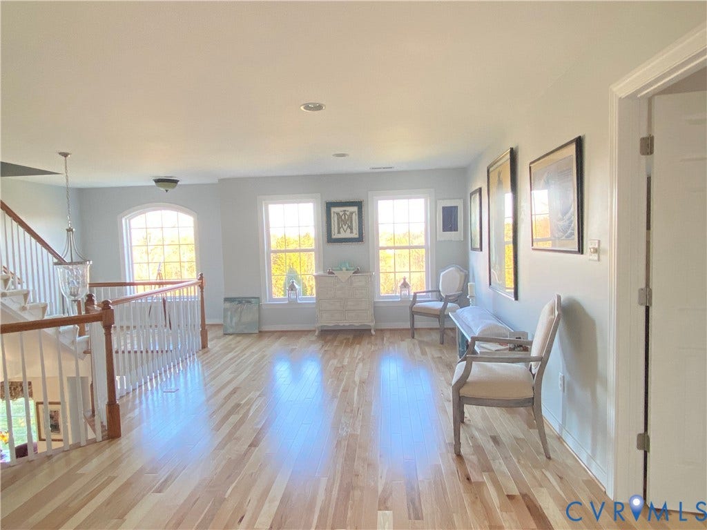 3267 Bayberry Lane, Goochland, VA 23063 Bright upper-level landing featuring wood-finish flooring, a white spindle staircase with wood handrails, and a transom window
