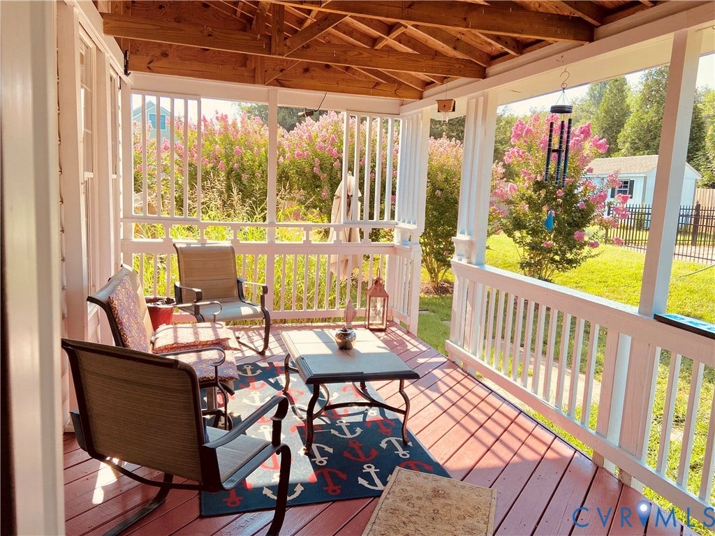 3267 Bayberry Lane, Goochland, VA 23063 Covered porch featuring a red-stained wood-finish floor, white painted railings, exposed wood ceiling beams, and a lush green lawn beyond