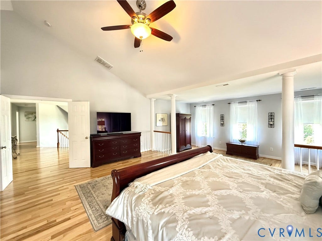 3267 Bayberry Lane, Goochland, VA 23063 Vaulted ceiling with a ceiling fan, hardwood flooring, multiple windows, and decorative columns
