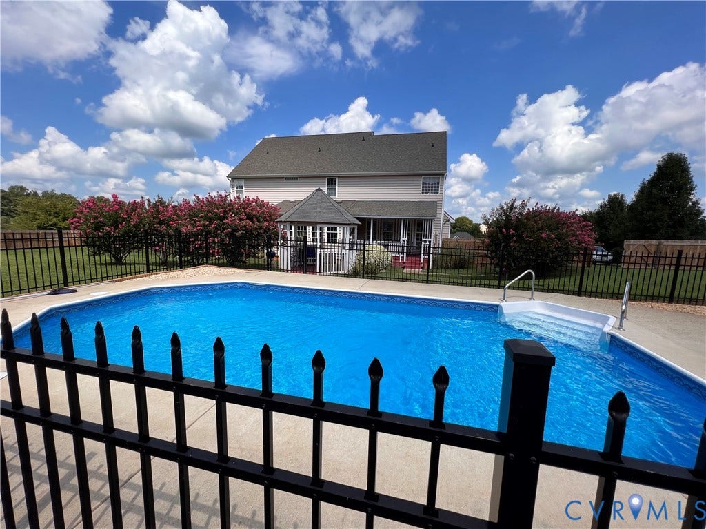 3267 Bayberry Lane, Goochland, VA 23063 In-ground swimming pool featuring broad steps, a surrounding concrete deck, and black wrought iron fencing