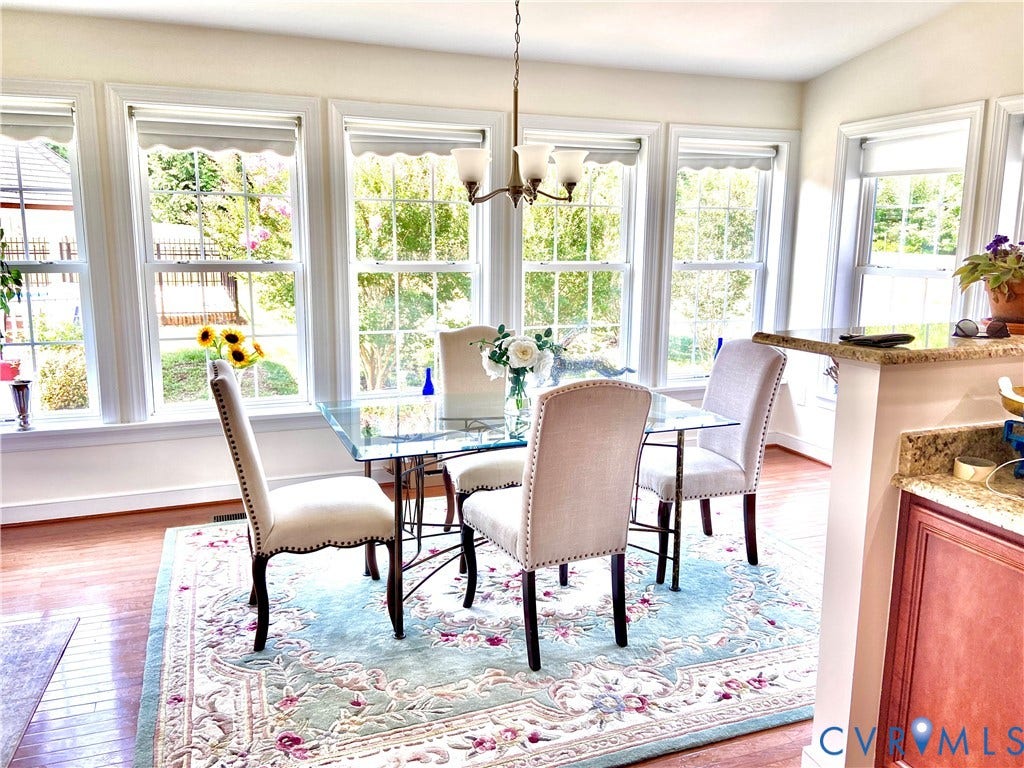 3267 Bayberry Lane, Goochland, VA 23063 Dining area featuring a series of large windows with white trim, wood-finish flooring, and a built-in countertop with granite-style finish