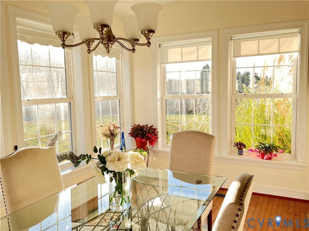 3267 Bayberry Lane, Goochland, VA 23063 Dining area featuring a five-light chandelier, multiple double-hung windows, light-colored walls, and wood-finish flooring