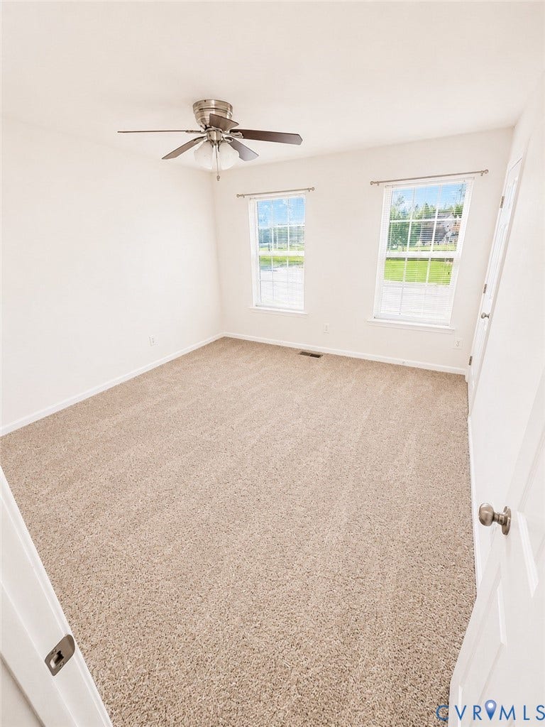 2312 Thomas Kenney Drive, Glen Allen, VA 23060 Bright and spacious bedroom flooded with natural light through dual windows, featuring neutral carpeting, a ceiling fan with integrated lighting, and white painted walls