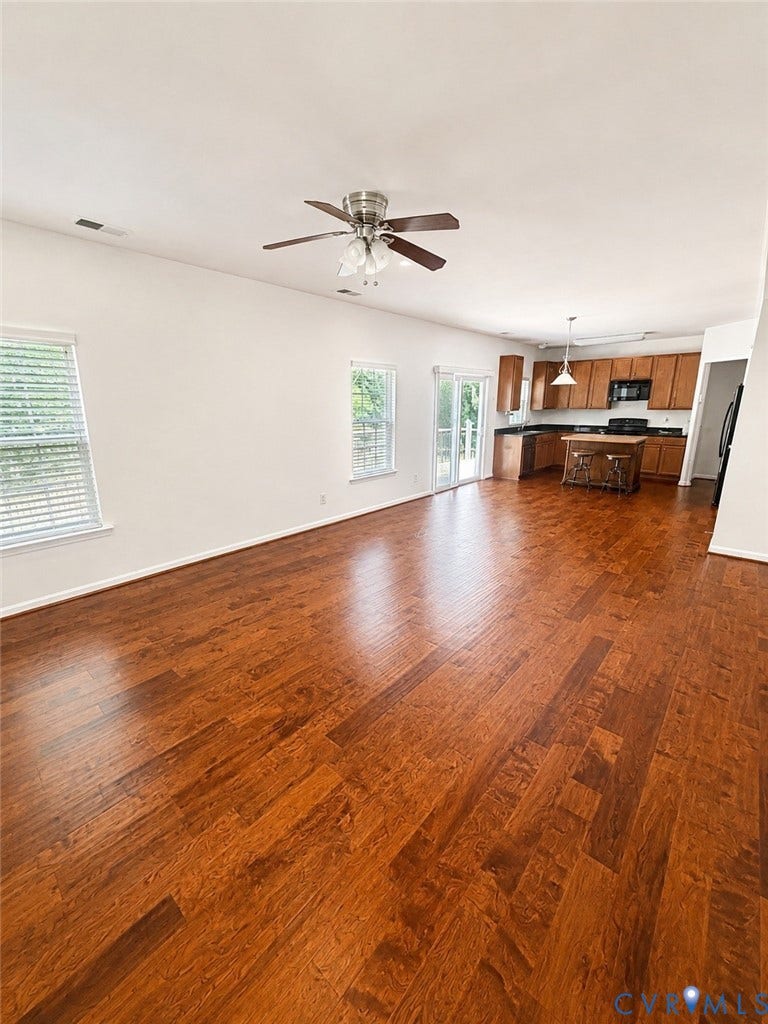 2312 Thomas Kenney Drive, Glen Allen, VA 23060 Hardwood flooring throughout, kitchen with wood cabinetry and dark countertops, stainless steel appliances, and ceiling fan with light fixture