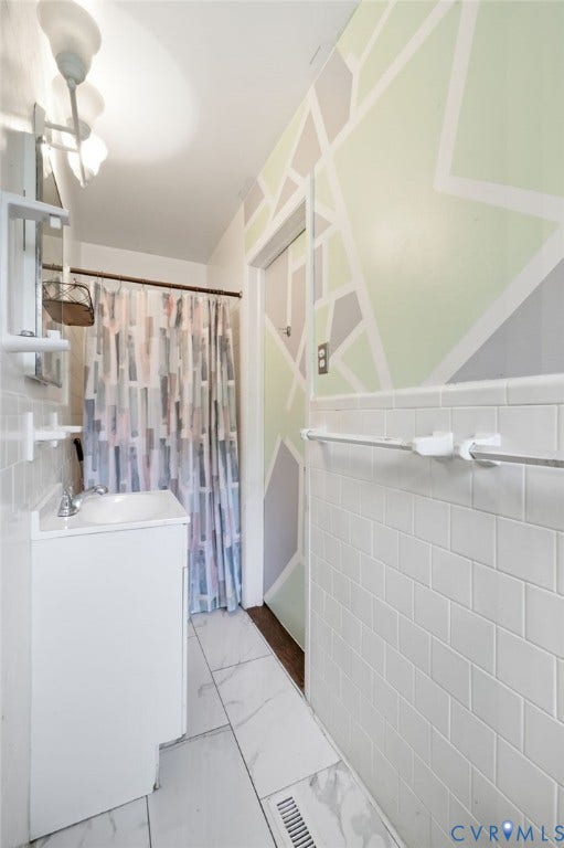 4021 Beulah Road, Chesterfield, VA 23237 Bathroom featuring a white vanity with integrated sink, white subway tile wainscoting, and large format marble-look tile flooring