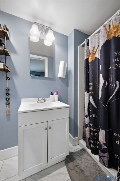 4021 Beulah Road, Chesterfield, VA 23237 Bathroom featuring a single vanity with storage, a recessed sink, and a framed mirror illuminated by a four-bulb light fixture