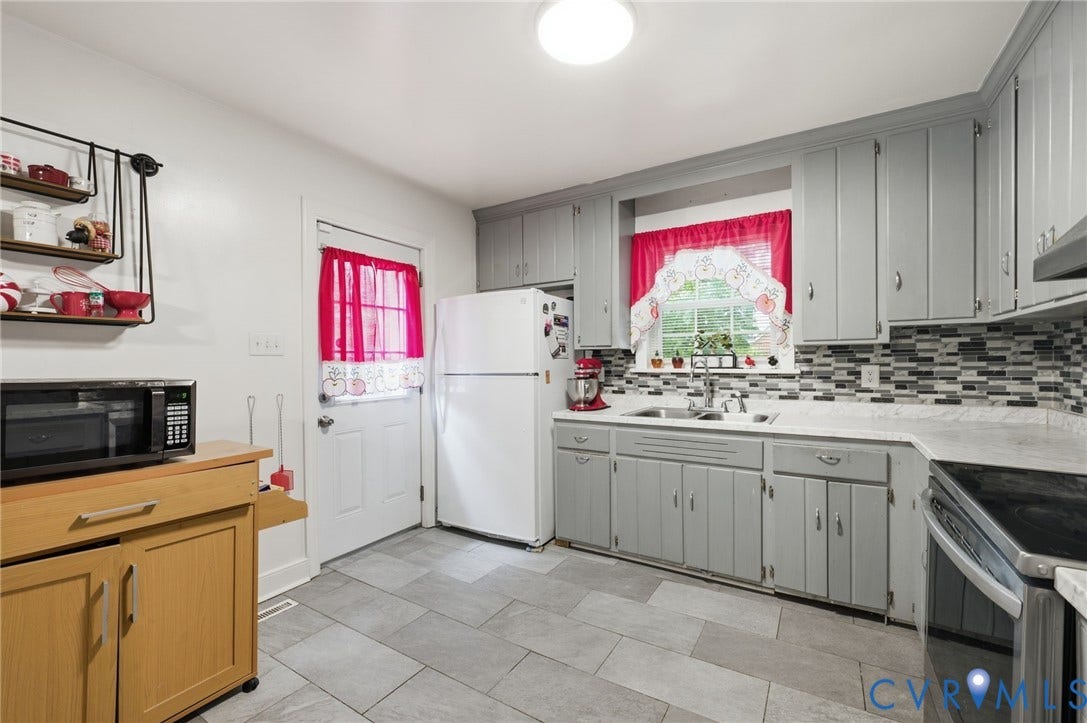 4021 Beulah Road, Chesterfield, VA 23237 Kitchen featuring gray shaker-style cabinetry, a multi-tone tile backsplash, light-toned countertops, and light gray tile flooring
